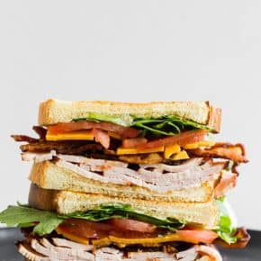 This turkey and cheese BLT sandwich is the perfect back to school sandwich. It combines lightly toasted bread with a homemade garlic basil mayonnaise, sliced turkey, sharp cheddar cheese, crispy bacon, sliced tomato and baby arugula. It's flavorful, easy to make and a step above your everyday bagged lunch sandwich.