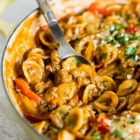 one pot ground chicken fajita pasta with a spoon in a yellow dish
