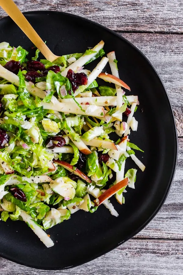 This tangy Brussels sprout apple slaw is a great addition to your fall menu. Crispy shaved Brussels sprout combined with dried cranberries, and apples all tossed in a homemade shallot whole grain mustard vinaigrette. You'll love this simple side dish!
