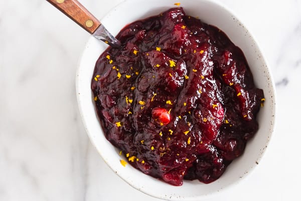 Cranberry Orange Sauce with Ginger in a bowl with orange zest on top. 