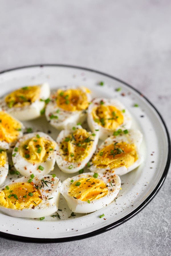 Instant Pot Hard Boiled Eggs on a plate sprinkled with fresh herbs and salt. 