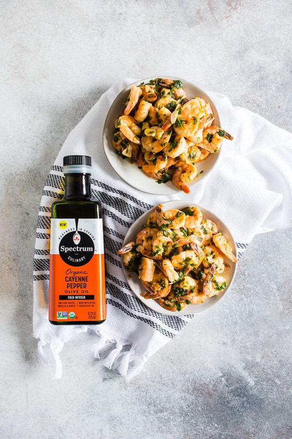 Spicy Garlic Cilantro Shrimp sitting on a table next to a bottle of olive oil. 