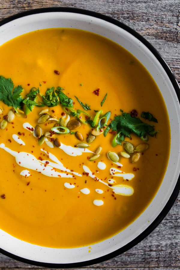 This spicy Thai pumpkin soup is ready in just 30 minutes and is packed full of flavor. It's super creamy and made with coconut milk, curry paste and tons of other Thai inspired flavors. Serve with all the toppings and devour! 