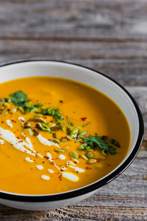 Spicy Thai Pumpkin Soup topped with pumpkin seeds and cilantro. 