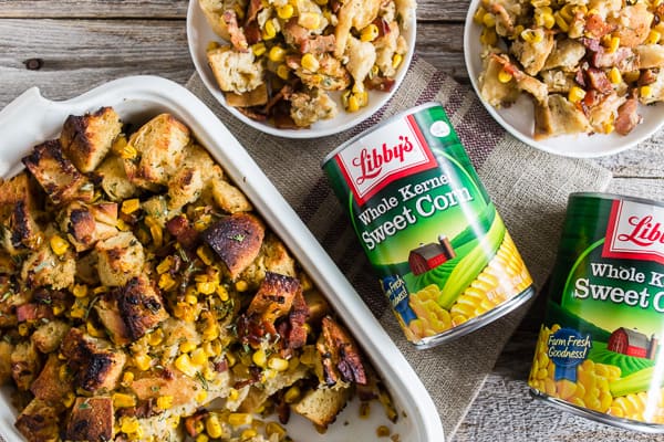 Bacon Corn Sourdough Stuffing sitting next to a few cans of sweet corn. 