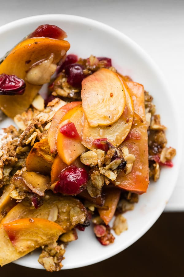 This vanilla bean persimmon crisp is the perfect holiday dessert. It's made with thinly sliced seasonal persimmons, chopped fresh cranberries, vanilla bean paste and topped with a homemade vanilla oat and almond mixture. You'll love this simple winter dessert!
