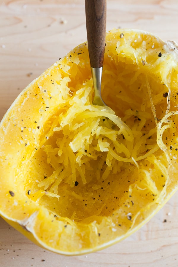 Cooked spaghetti squash half with a fork in the flesh