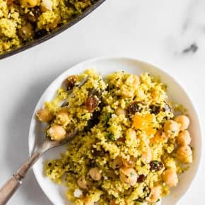 This Moroccan couscous with chickpeas is flavored with ras el hanout, golden raisins, dried apricots, and fresh herbs. It's the perfect side dish that packs a punch in the flavor department. Trust me, you'll love this dish!