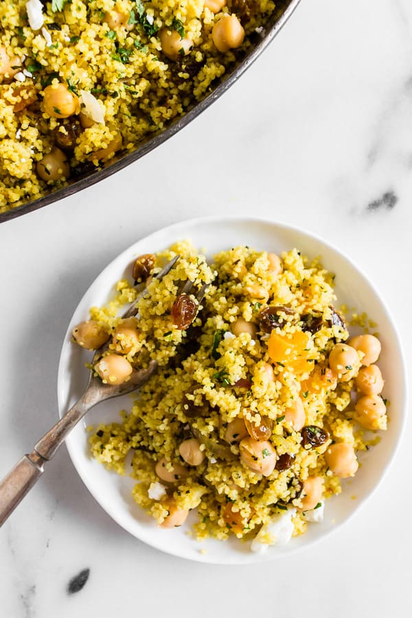 This Moroccan couscous with chickpeas is flavored with ras el hanout, golden raisins, dried apricots, and fresh herbs. It's the perfect side dish that packs a punch in the flavor department. Trust me, you'll love this dish!