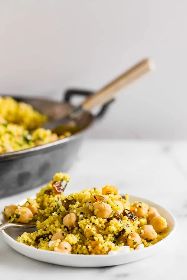This Moroccan couscous with chickpeas is flavored with ras el hanout, golden raisins, dried apricots, and fresh herbs. It's the perfect side dish that packs a punch in the flavor department. Trust me, you'll love this dish!