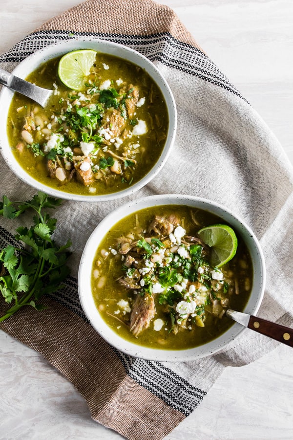 This Instant Pot pork chili verde is packed full of tomatillos, cilantro, green chiles, tender pork shoulder, and beans. It's great when topped with Cotija cheese, cilantro, and crispy corn chips. 