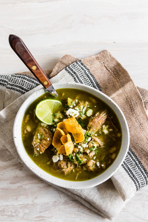 This Instant Pot pork chili verde is made with cilantro, tomatillos, garlic, pork and soft white beans. Great when topped with cotija cheese and crispy corn chips!