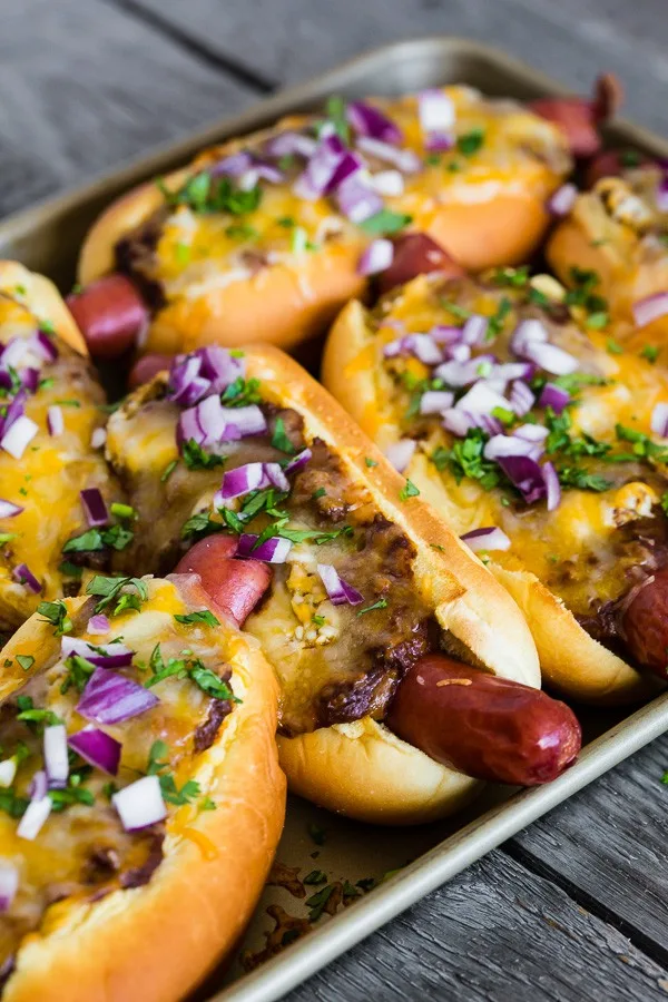 Oven Baked Chili Cheese Dogs sprinkled with red onion. 