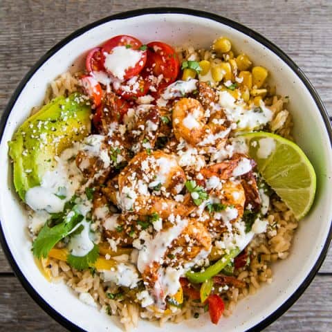 These chipotle shrimp fajita bowls are a quick weeknight dinner option that will make the whole family happy. It's full of flavorful chipotle lime shrimp that are served over rice with sauteed vegetables and drizzled with a cilantro lime Greek yogurt sauce. It's super simple and can be made in just 30 minutes!