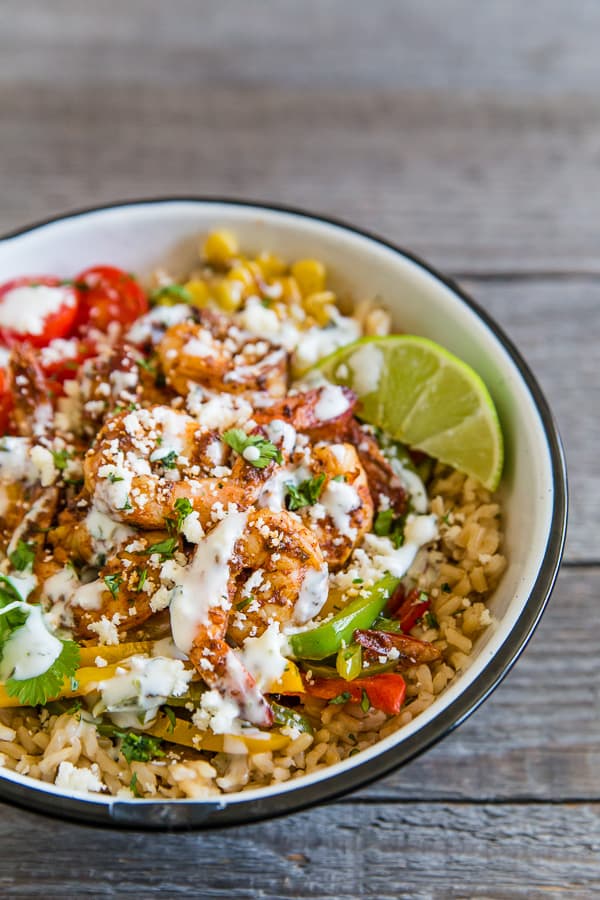 These chipotle shrimp fajita bowls are a quick weeknight dinner option that will make the whole family happy. It's full of flavorful chipotle lime shrimp that are served over rice with sauteed vegetables and drizzled with a cilantro lime Greek yogurt sauce. It's super simple and can be made in just 30 minutes!