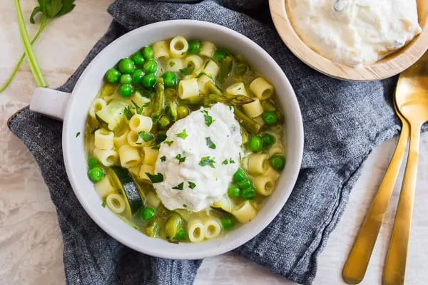 Spring Minestrone Soup with Lemon Whipped Ricotta served with extra topping. 