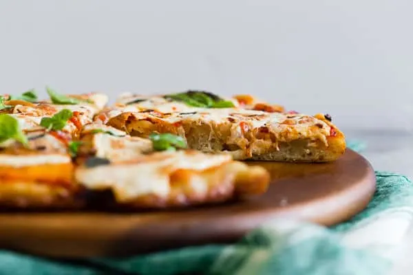 This smoked mozzarella pizza is topped with a light layer of marinara sauce, freshly smoked mozzarella cheese, fresh herbs and a sprinkle of grated Parmesan. It's packed full of flavor and cooks in just about 20 minutes. 