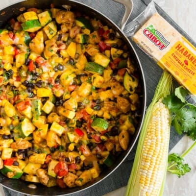 This Tex Mex chicken and vegetable skillet is ready in just 30 minutes and a great way to use up all of those summer vegetables. It's packed full of zucchini, yellow squash, sweet summer corn, bell peppers, seasoned chicken and topped with the just the right amount of spicy Cabot habanero cheddar cheese. Serve alone or piled high on rice. Either way, it's totally delicious!