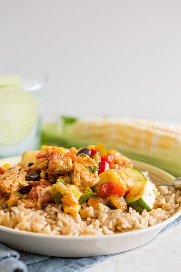 tex mex chicken and vegetable skillet served on a plate with rice.