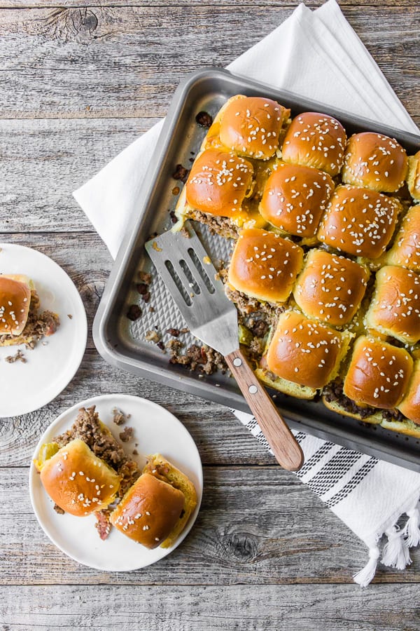 baked bacon cheeseburger sliders on a sheet pan and plate