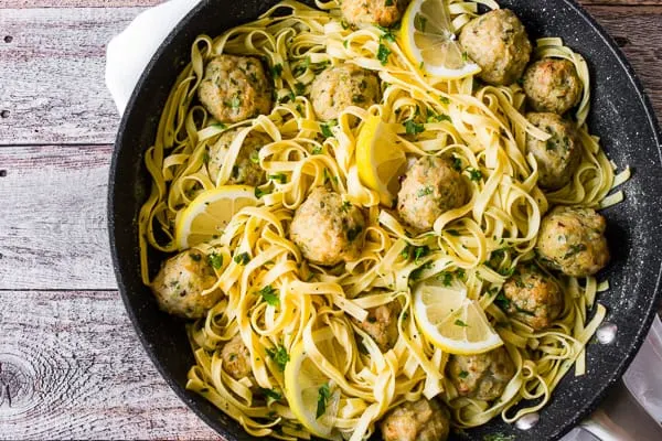 Baked Chicken Francese Meatballs in a skillet with pasta and sauce