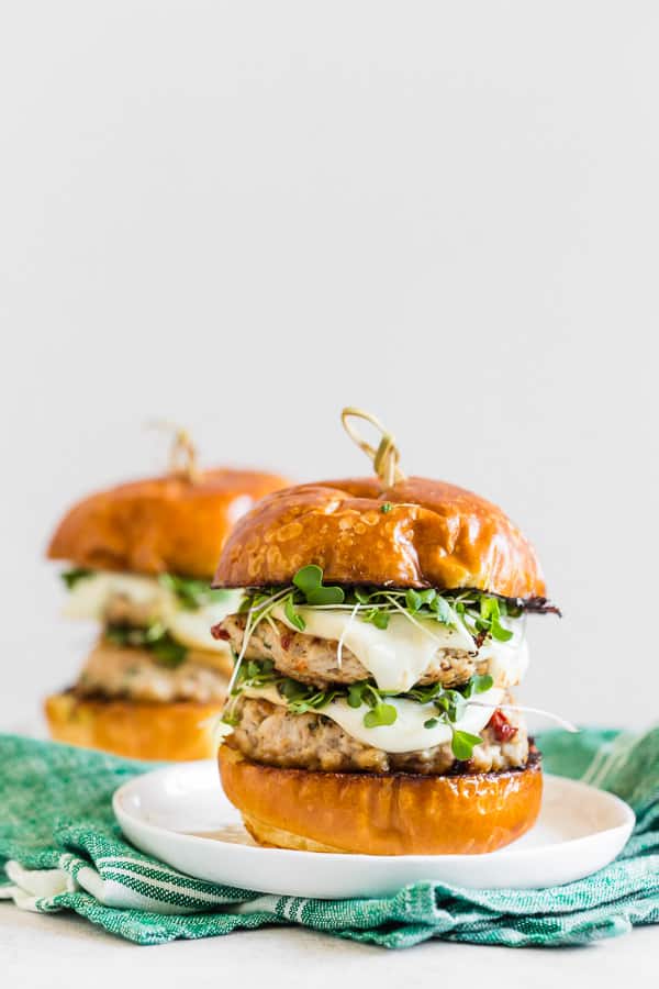 two sun dried tomato chicken burgers on a plate