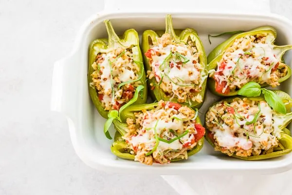 ground chicken stuffed bell peppers in a white dish