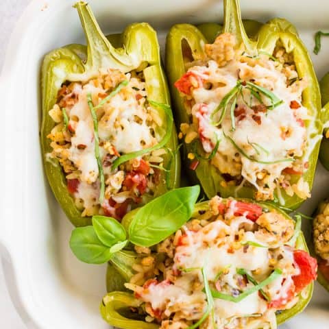 ground chicken stuffed bell peppers in a white dish