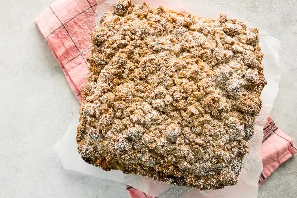 sourdough discard cinnamon crumb cake on parchment paper with a pink napkin underneath 
