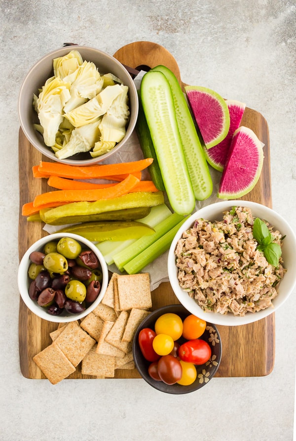 lemon herb tuna salad snack board filled with fresh vegetables and olives