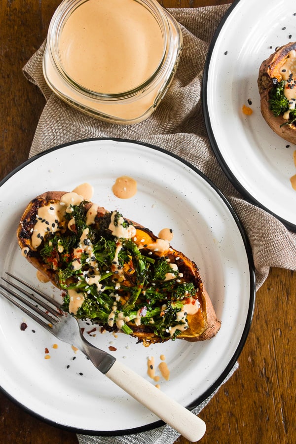 broccoli rabe and hummus stuffed sweet potatoes on a plate with forks