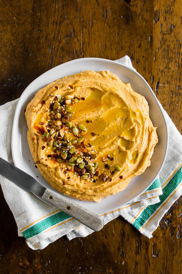 pumpkin hummus on a plate sitting on a table.