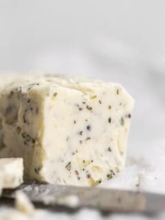 garlic herb compound butter sitting on parchment paper