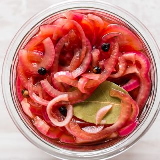 overhead shot of pickled red onions in small glass jar