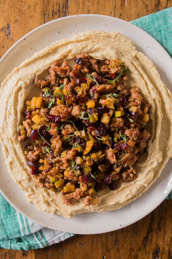 Thanksgiving stuffing topped hummus on a white plate