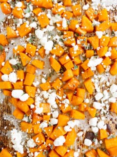 honey roasted butternut squash sprinkled with goat cheese on a sheetpan