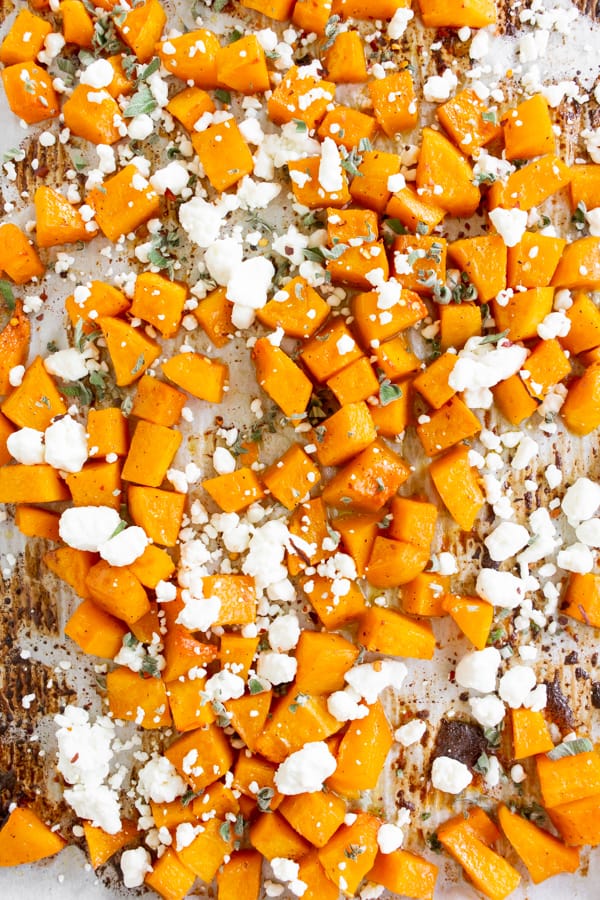 Honey roasted butternut squash on a sheet pan with goat cheese and sage