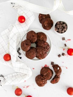chocolate peppermint bark cookies on a white table surround by chocolate chips