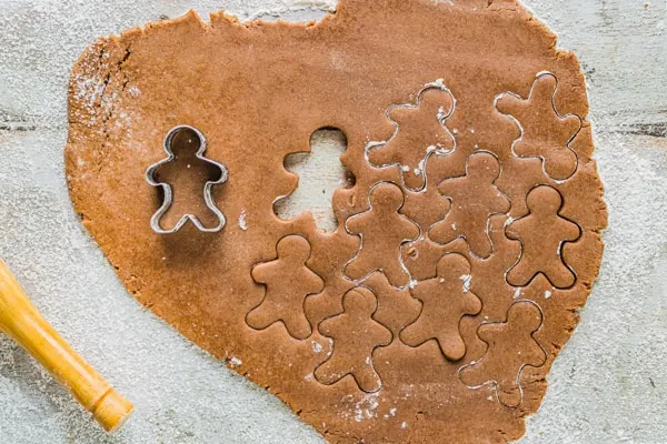 soft gingerbread cutout cookies getting cut out with cookie cutters