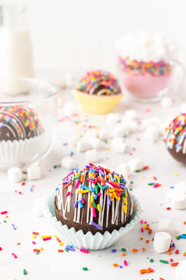 chocolate strawberry funfetti hot chocolate bombs sitting on a table