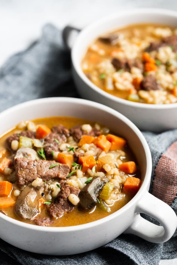 instant pot beef barley soup in a bowl with a napkin