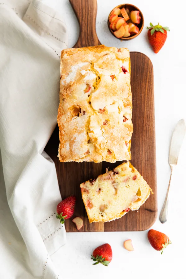 strawberry rhubarb pound cake sliced on a wooden serving board.