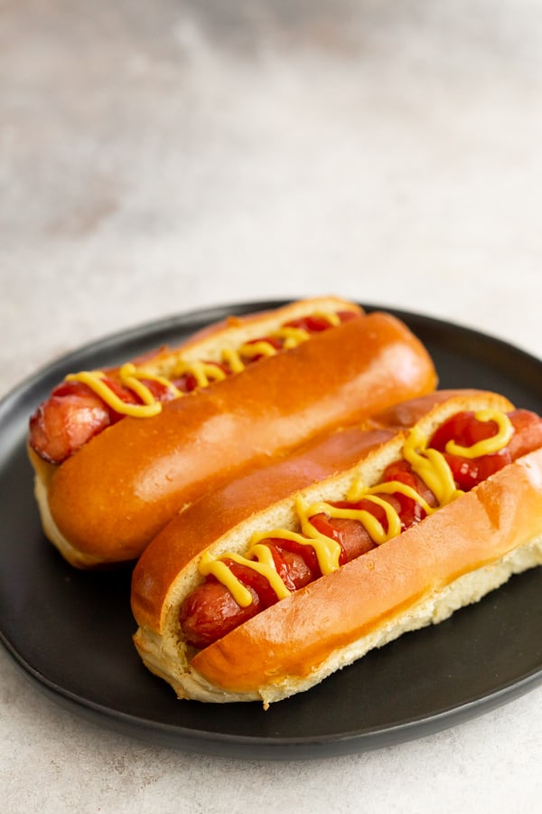 2 air fryer hot dogs on a plate.