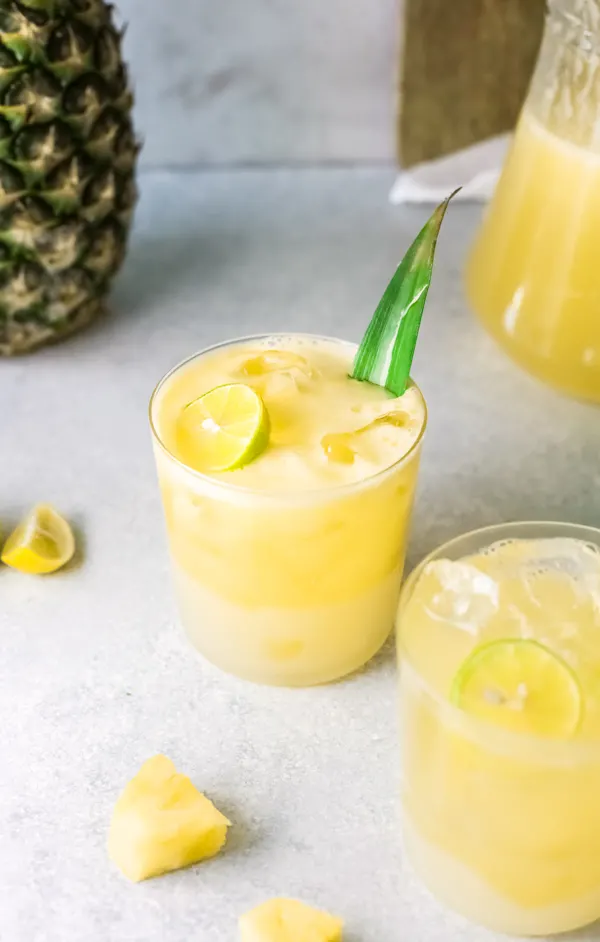 Pineapple Agua Fresca in a glass with a pineapple leaf garnish.