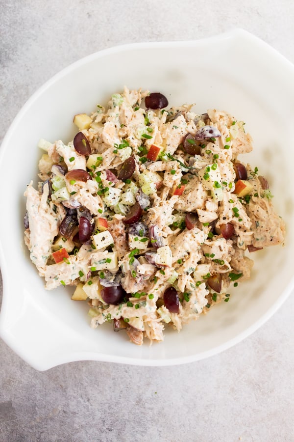 the best chicken salad mixed in a bowl and topped with fresh minced chives. 