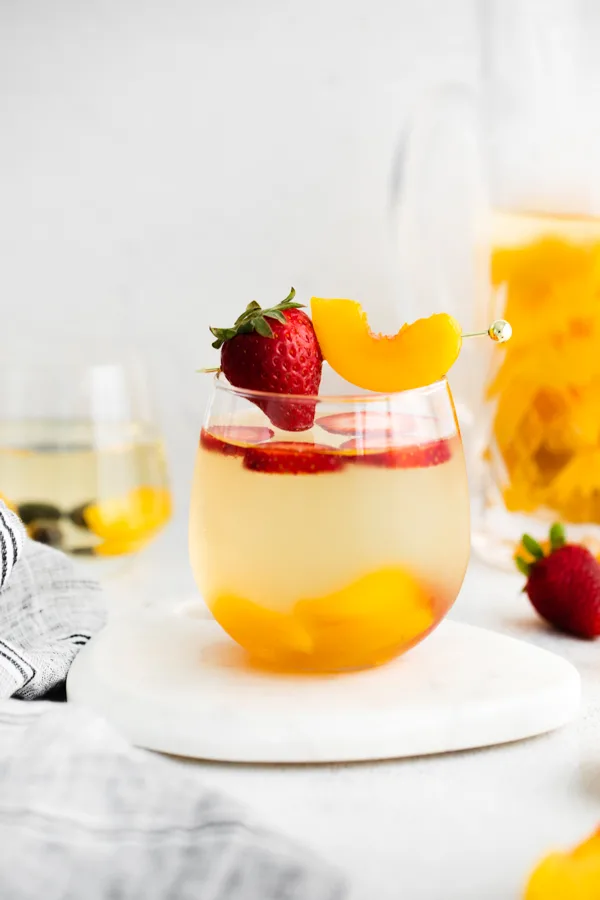chilled white wine peach sangria in a serving glass. 