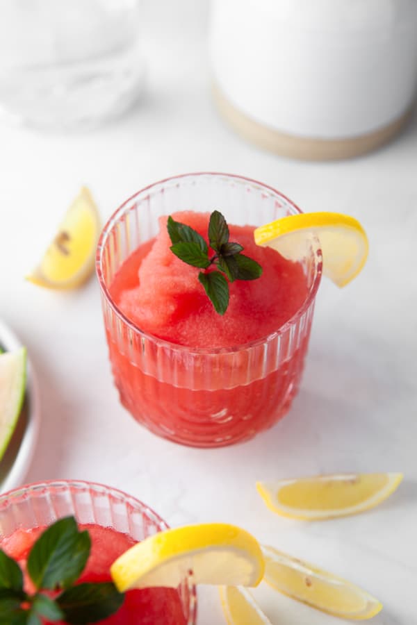 Watermelon Frose served in a glass with a garnish of fresh mint. 