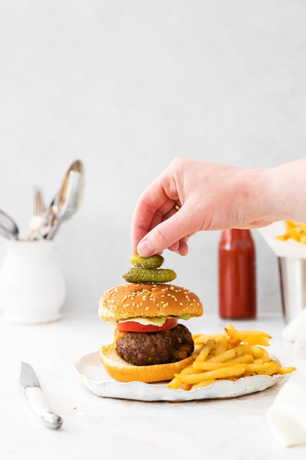 air fryer Juicy Lucy burger with a hand grabbing for the burger. 