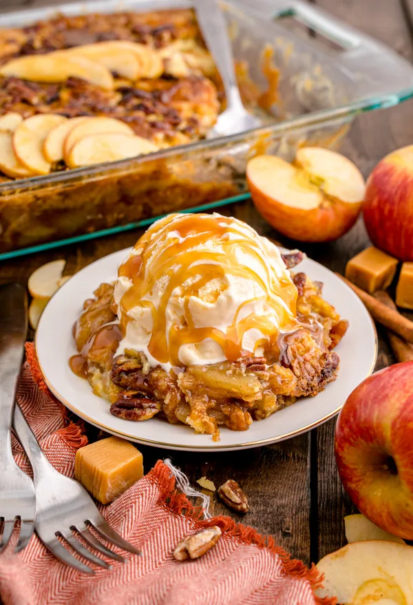 Caramel Apple Dump Cake topped with ice cream with caramel. 