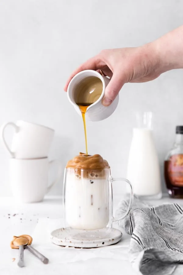 Pouring maple syrup onto their Maple Whipped Coffee. 